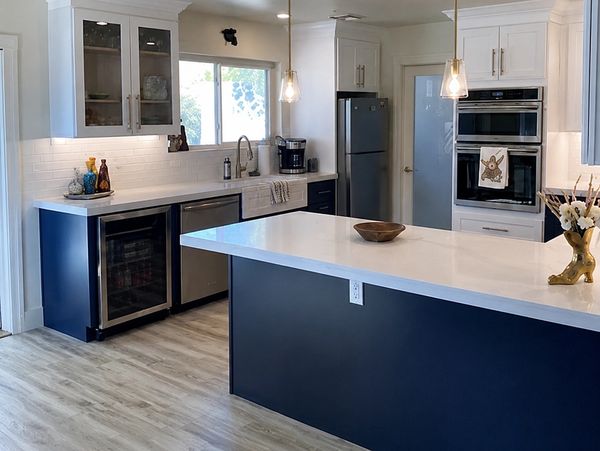 Modern kitchen with blue and white cabinetry and a large island.