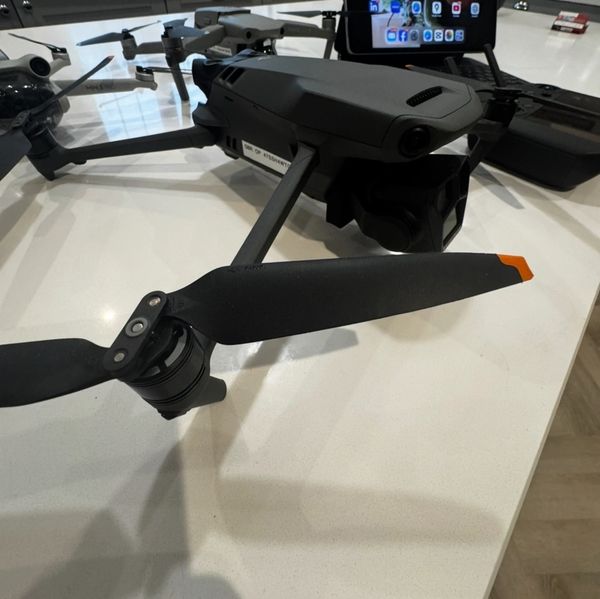 A drone with propellers resting on a white kitchen counter.