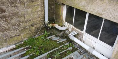 Old basement window with moss and failing covering