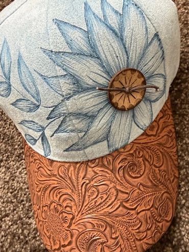 Decorative boot with blue floral embroidery and a carved wooden button detail.