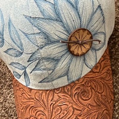 Decorative boot with blue floral embroidery and a carved wooden button detail.
