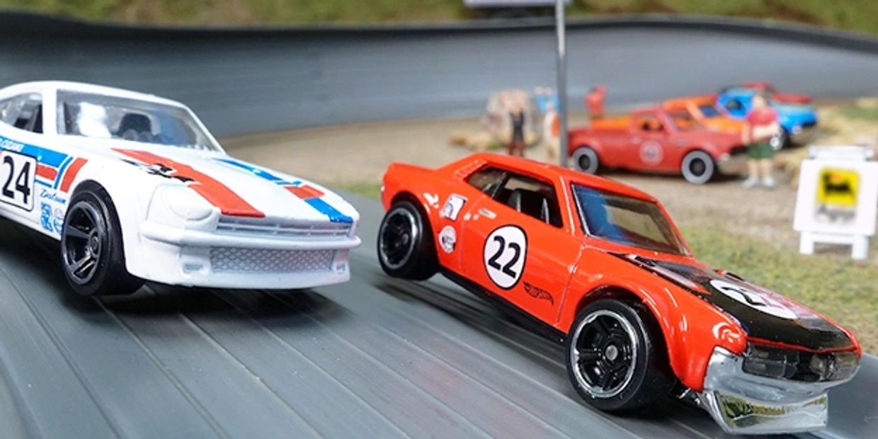 Two toy race cars, one red and one white, on a miniature race track.