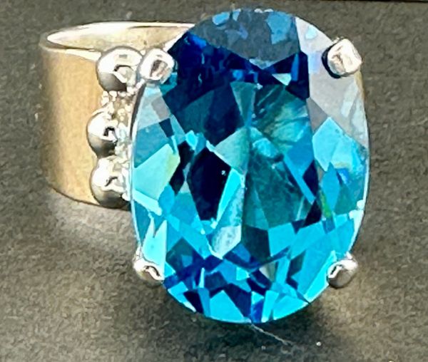 glue topaz in ss and 14k gold with a large blue topaz ston in an adjustable ring as usual.