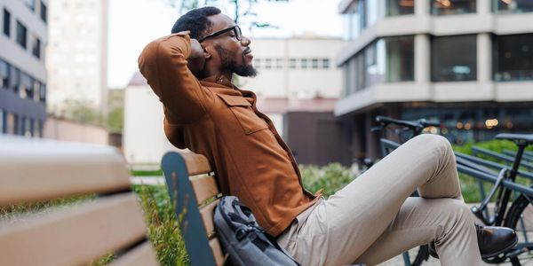 Man relaxing on a bench outdoors.