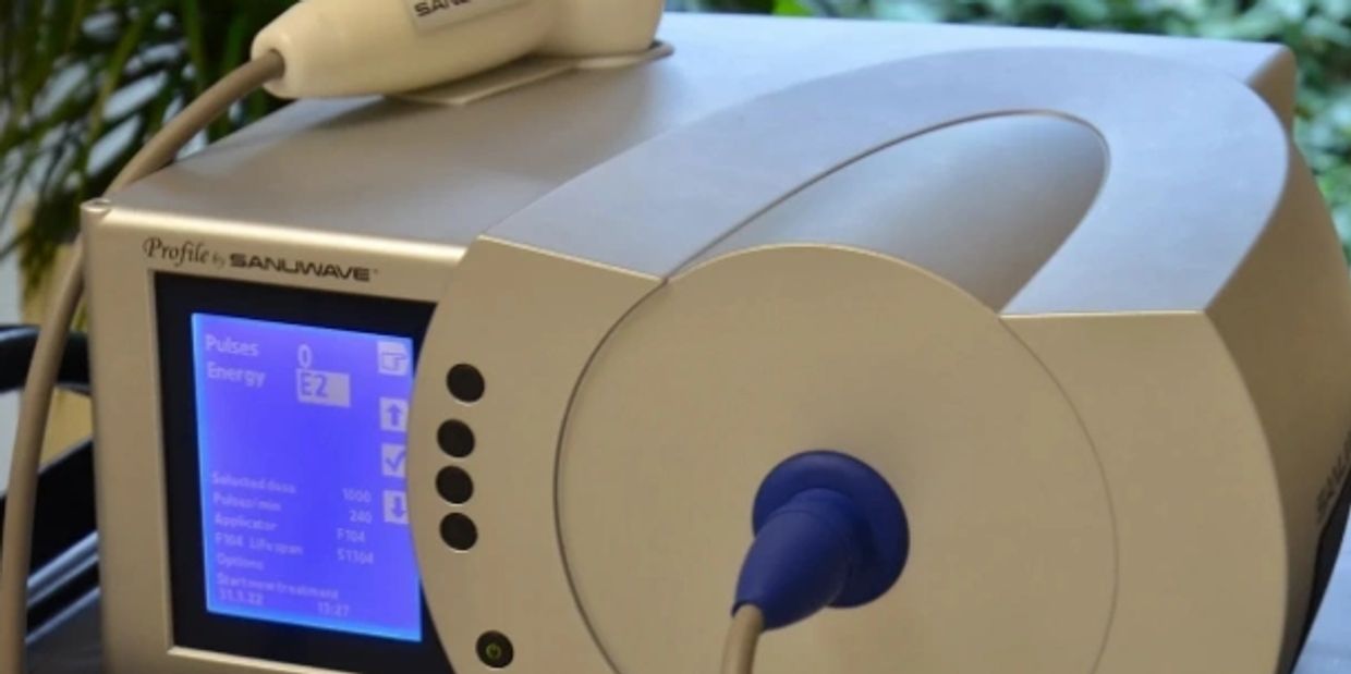 Close-up of a Sanuwave medical device with digital display and connected probe.