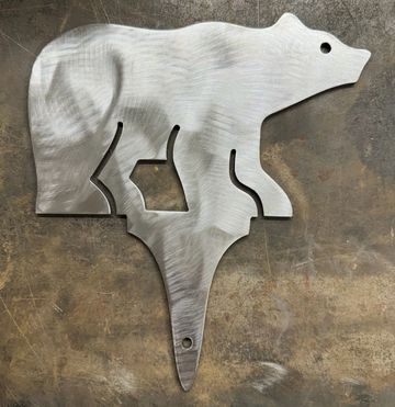Metal artwork of a bear with a detachable fish.