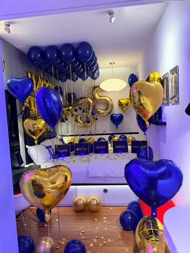 Room decorated with blue and gold heart balloons and sensory signs.