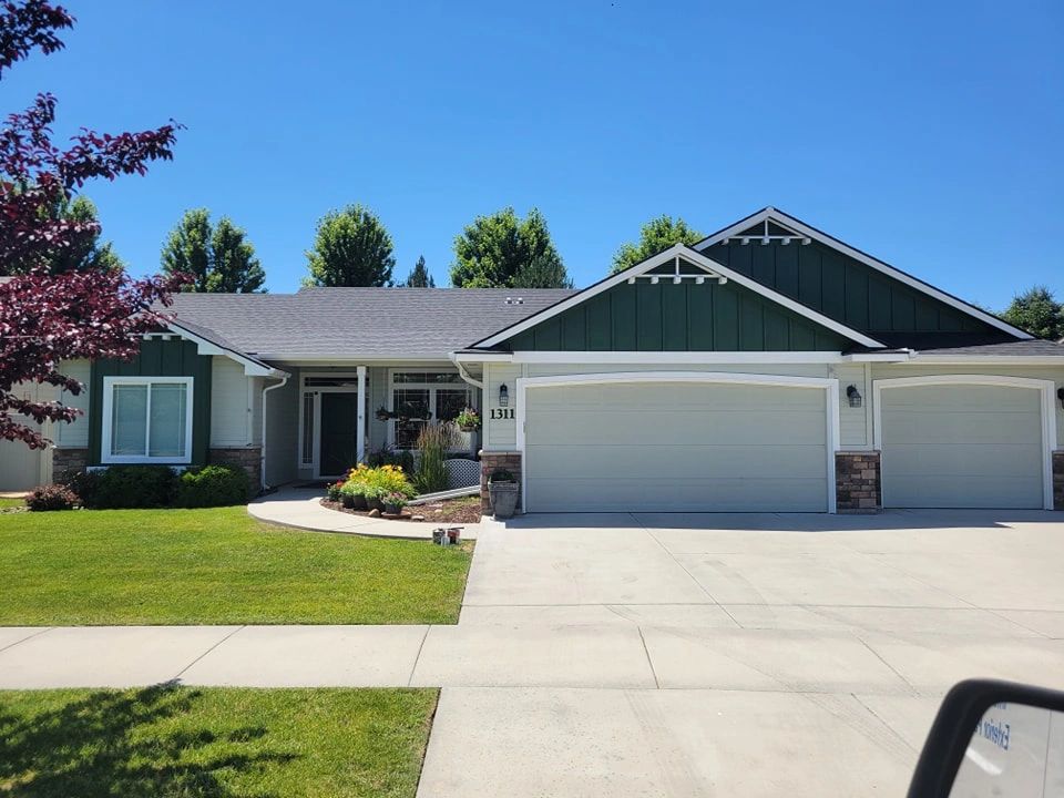 Exterior of a house painted a light gray with turquoise green eves and white trim.
