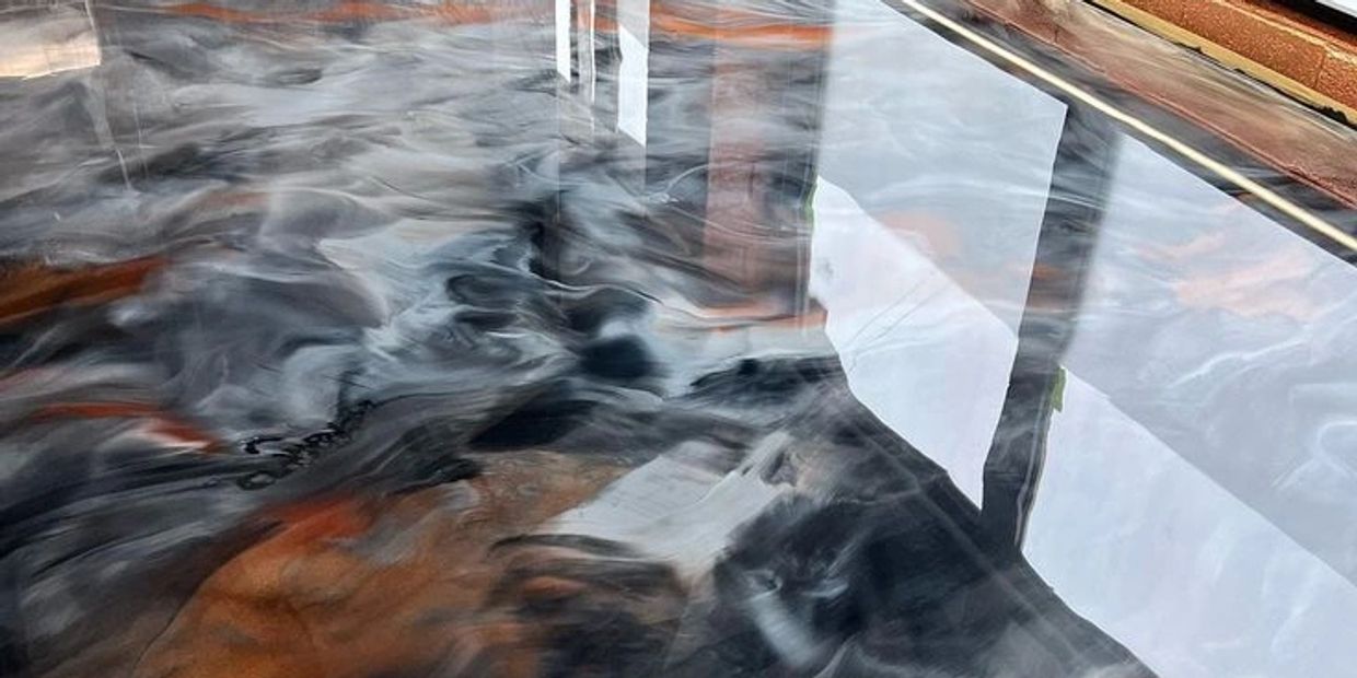 A living room floor epoxied with metallic gray, copper, white, and black.