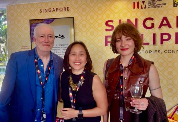 Three people posing at a Singapore event.