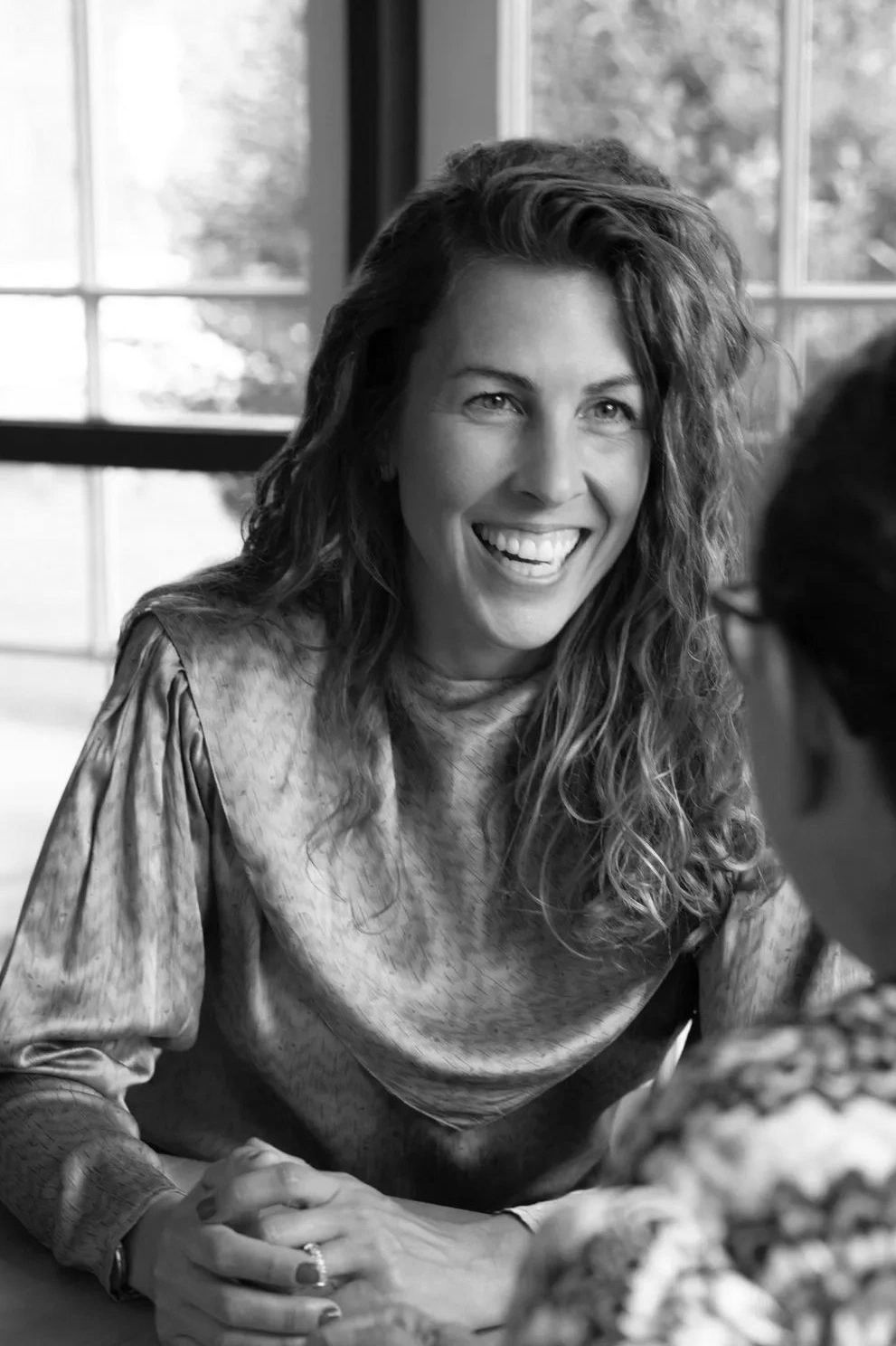 Joly-Lowdermilk, seated and smiling during coaching session