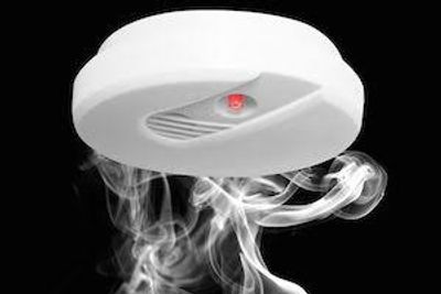 Smoke detector sensing smoke with red warning light.