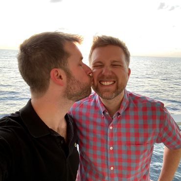 Husbands Todd and Rob kiss on cheek at sea