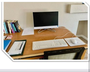 A clean desk with a computer, keyboard, mouse, and books.