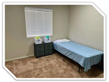 Minimalist bedroom with single bed and small dresser.