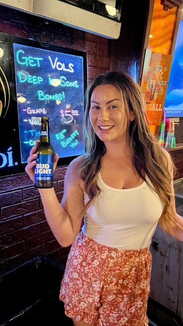 Bartender holding a bottle of beer at Rooster's Bar in Knoxville.