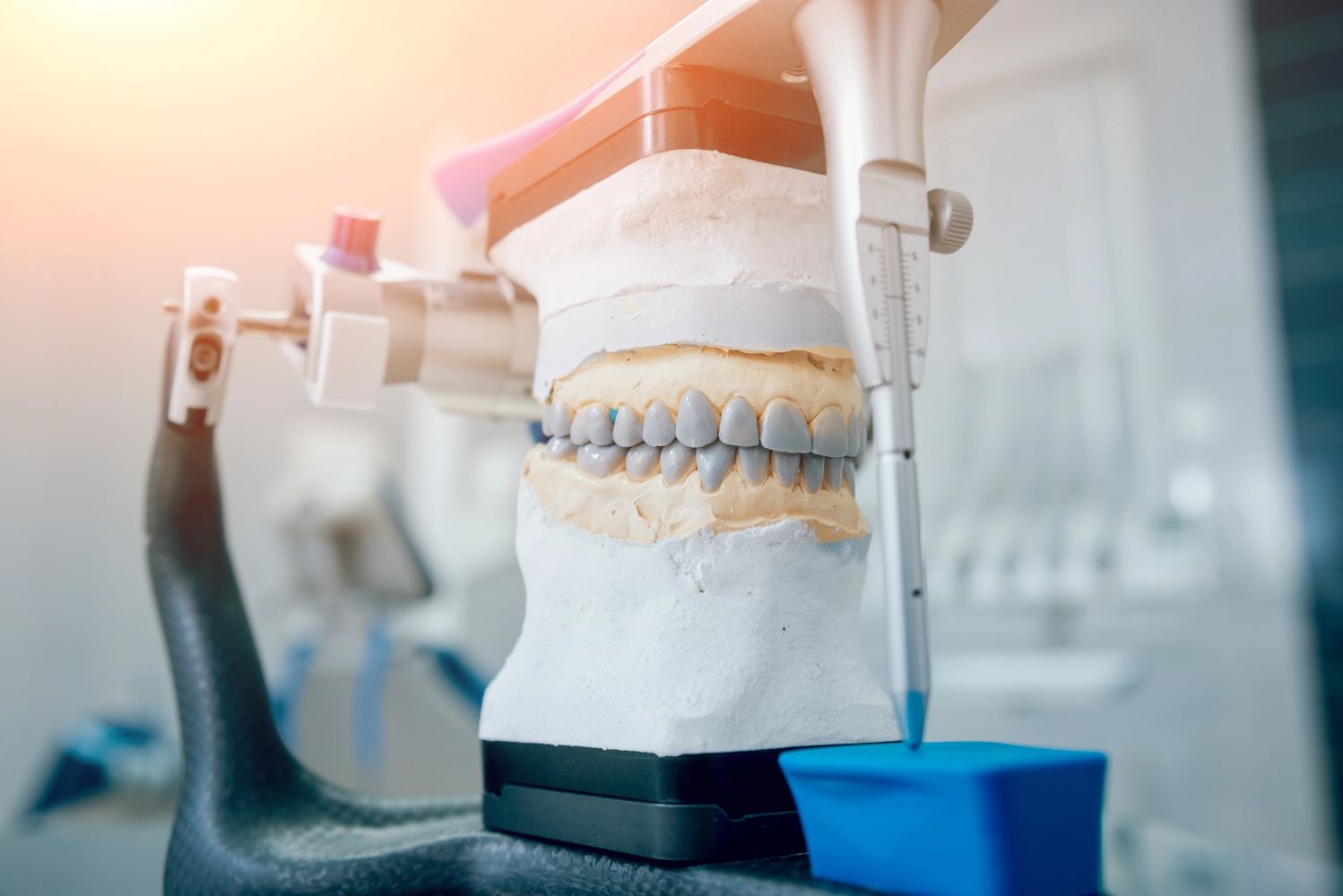 dental technician working with articulator in dental lab