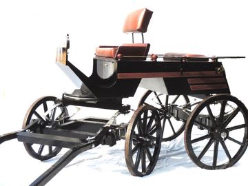 Victorian-style carriage with leaf spring suspension and wooden spoked wheels.