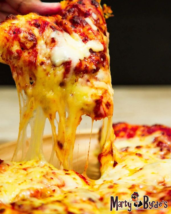 A cheesy pizza slice being lifted, with melted cheese stretching beautifully.