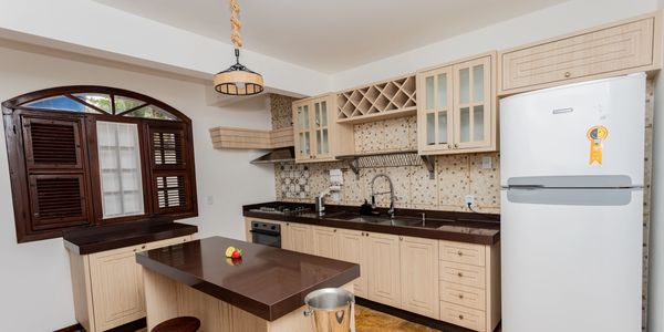 Modern kitchen with wooden cabinets, dark countertops, and a white refrigerator.