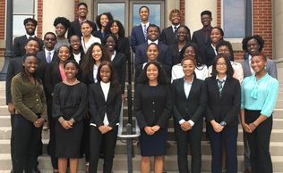 Group photo of young professionals and students dressed formally.