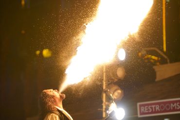 A fire breather performing a fiery stunt at night.