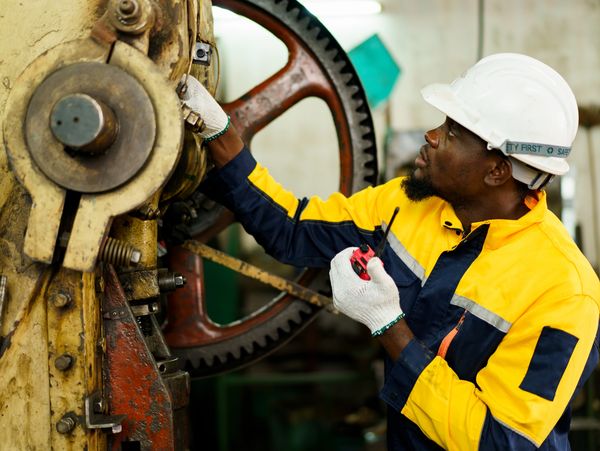 Man inspecting large factory machinery.
