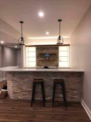 Basement bar lighting installation with recessed and pendant lighting for balanced illumination.