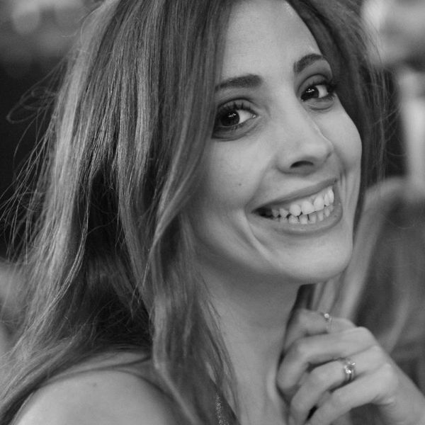 Black and white close-up of a smiling woman with long hair.