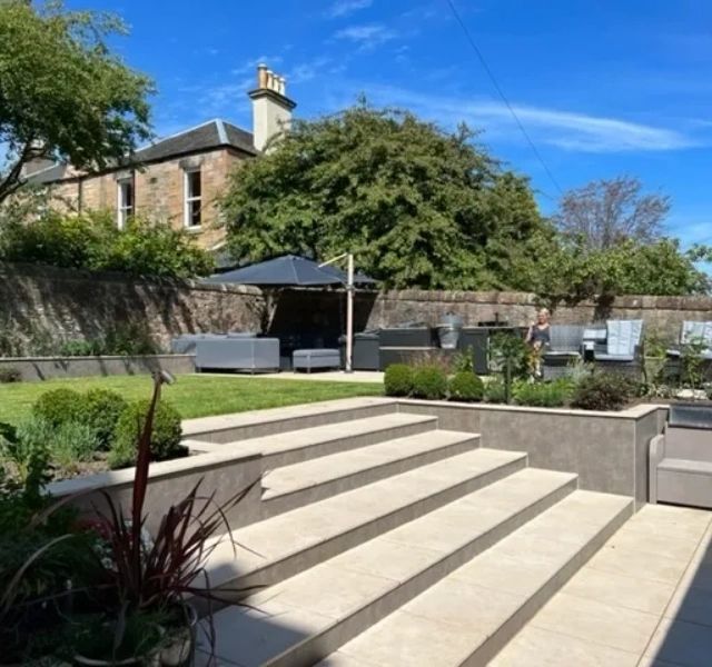 Outdoor porcelain patio, steps, and walls fitted by Traynor Tile, Mosaic & Stone in Edinburgh.