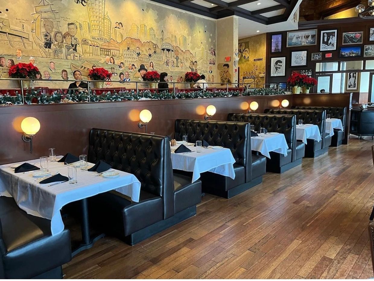 Elegant restaurant booths with white tablecloths and festive decor.