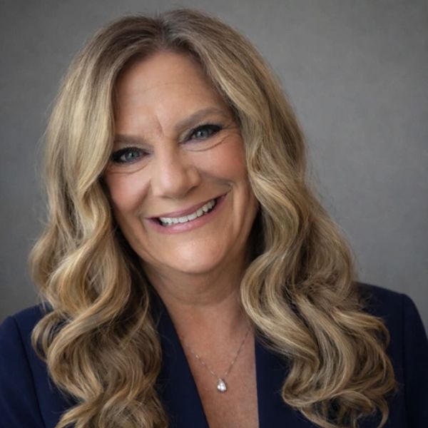 Smiling woman with long wavy blonde hair.