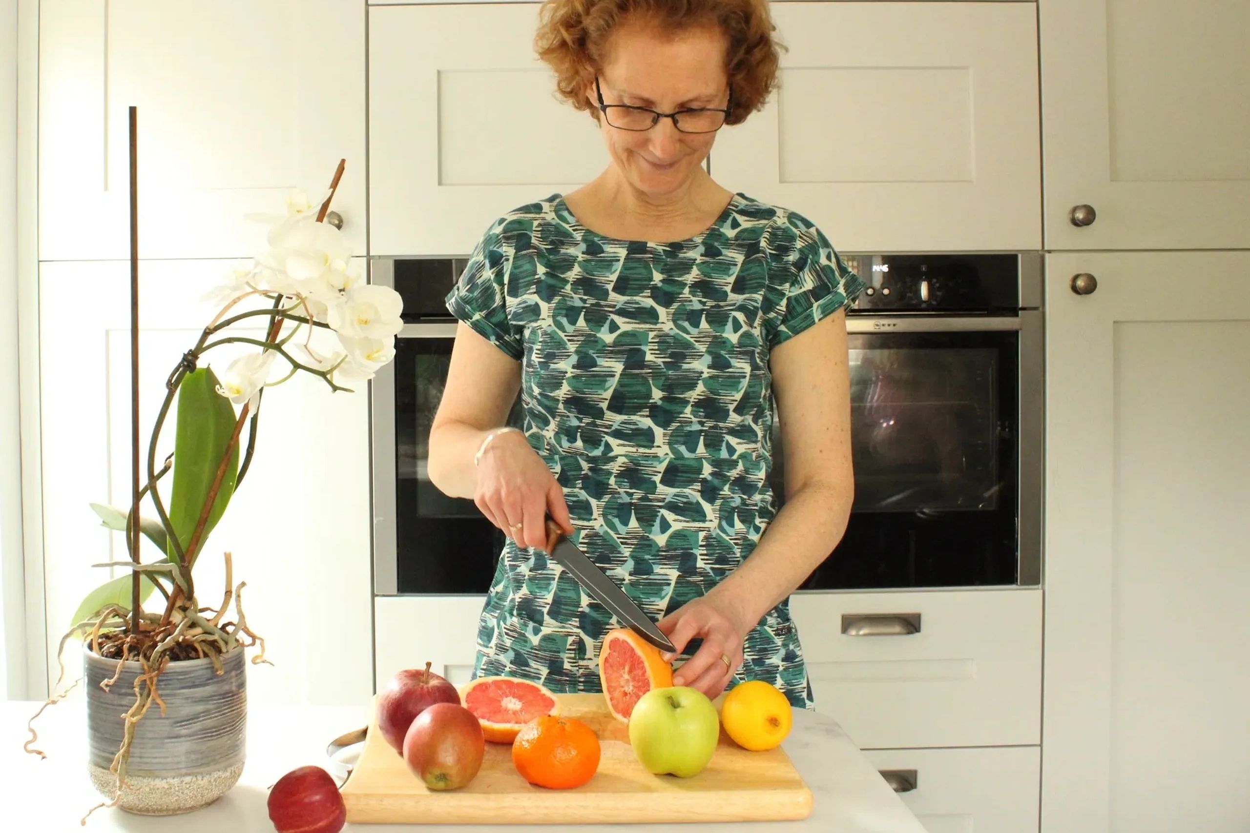 Helen Moorhouse Nutritionist in Derby cutting up fruit in the Kitchen.