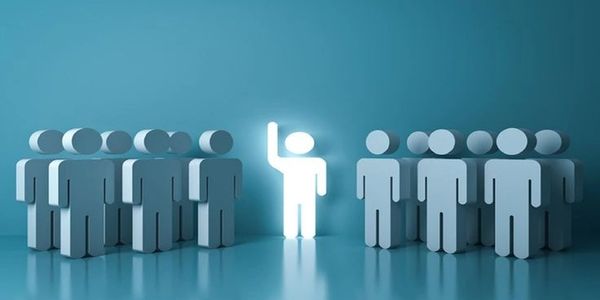 One glowing figure raising hand among groups of gray figures.