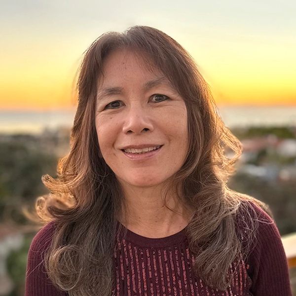Smiling woman with long hair at sunset outdoors.
