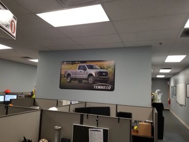 Office cubicles with a Tenneco truck poster on the wall.