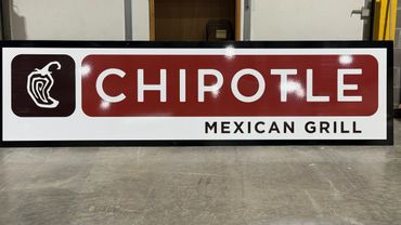 A Chipotle Mexican Grill sign with a chili pepper logo on a white and red background.