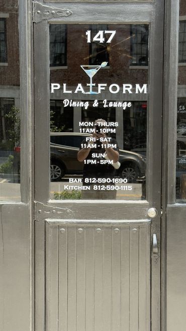 Glass door of Platform Dining & Lounge with hours and contact info.