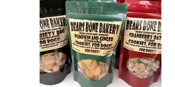 Three flavors of Bears Bone Bakery dog cookies in colorful bags.