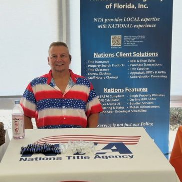 Man standing at a Nations Title Agency promotional table.