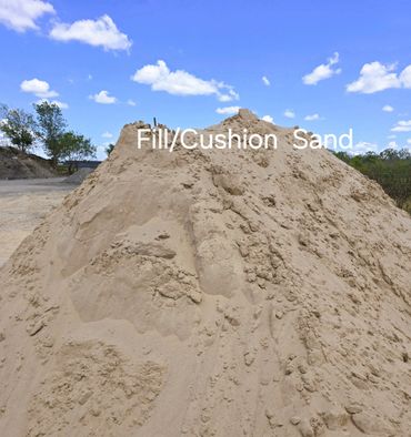 Large pile of fill and cushion sand under blue sky.