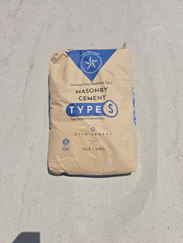 A bag of Type S Masonry Cement weighing 75 pounds on a concrete surface.