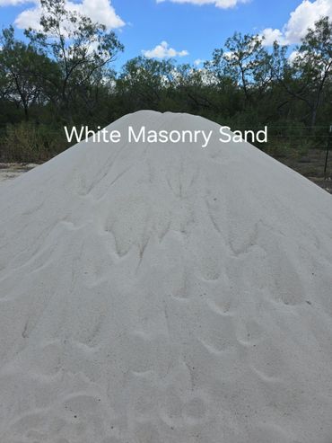 Pile of white masonry sand outdoors under blue sky.
