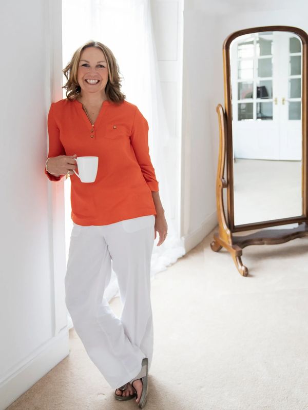 Sally smiling standing in front of a mirror