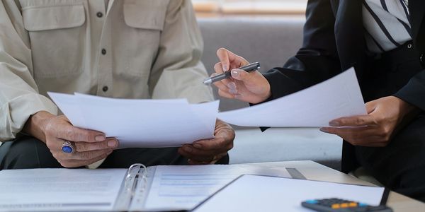 Two people reviewing and discussing documents together at a table.