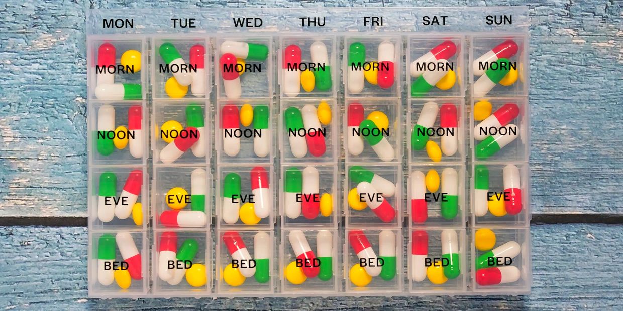 Weekly pill organizer with color-coded capsules and tablets.