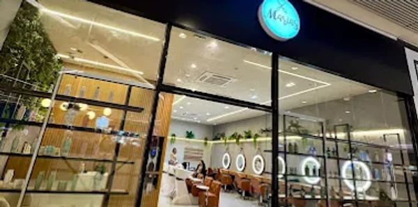 Imagem do salao, com a vitrine do shopping contendo produtos de cuidados pra casa, e o salao atras.