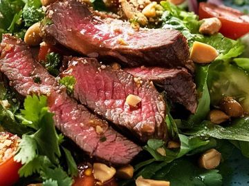 A vibrant salad with medium-rare steak slices and fresh vegetables.