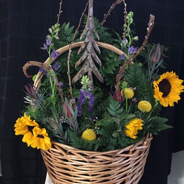 Memorial piece with a hand carved wooden pine tree and florals chosen by the family to honor their l