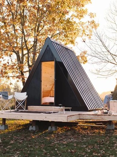 A modern A-frame glamping pod amidst nature
